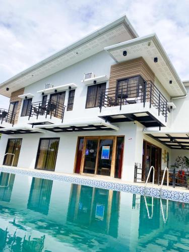 a house with a swimming pool in front of it at Casa De Española Hotel and Resort in Aritao