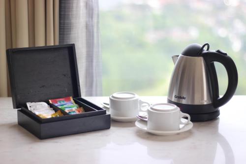 a tea set with a tea kettle and cups on a table at InterContinental Bandung Dago Pakar by IHG in Bandung