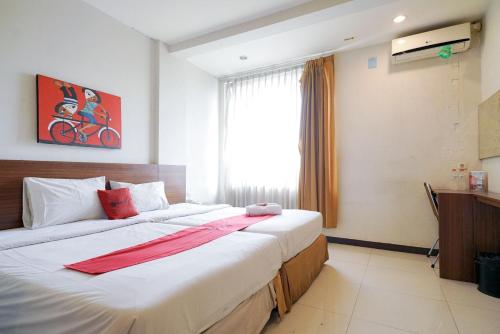 1 dormitorio con 2 camas y ventana en RedDoorz Near Braga Street, en Bandung