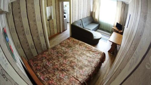 ノヴォシビルスクにあるApartments near Railway Stationのベッド、ソファ、椅子が備わる客室です。