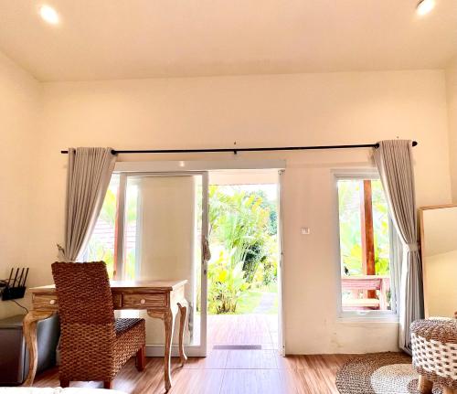 a dining room with a table and a sliding glass door at Agung Wiwin Homestay & Restaurant in Mengwi