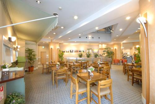 福岡市にあるHOTEL Third Place Hakataのテーブルと椅子が備わるレストラン