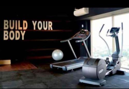 a gym with a treadmill and a sign that reads build your body at Cozy apartment in Louis kienne simpanglima in Semarang