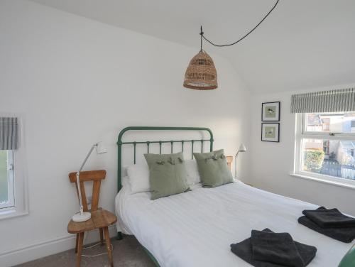 a bedroom with a bed and a chair and windows at Disgwylfa in Moelfre