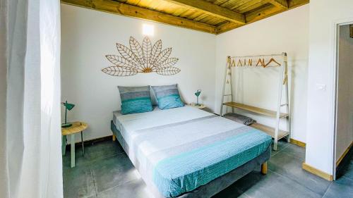 a bedroom with a bed with blue pillows at Villa Fleur de Jade in Saint-Louis