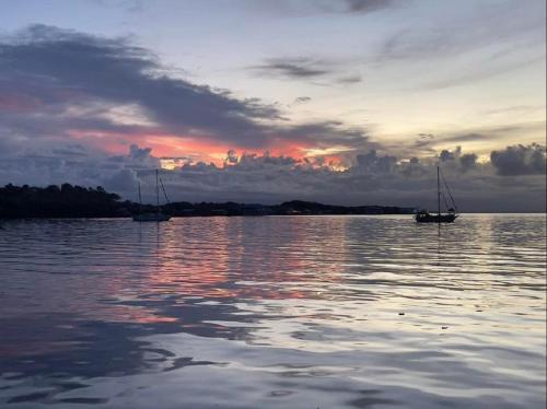 dwie łodzie na wodzie o zachodzie słońca w obiekcie Villa AMAYA w mieście Bocas del Toro