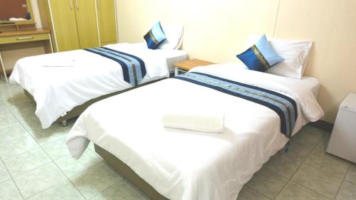 a hotel room with two beds in a room at Goody Hotel in Bangkok