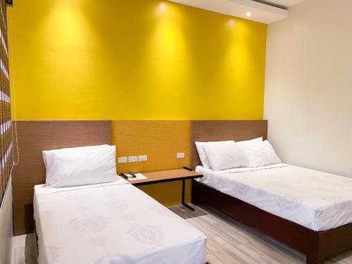 a room with two beds and a yellow wall at Casa De Española Hotel and Resort in Aritao