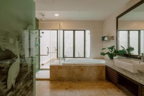a bathroom with a tub and a sink at Borneo Beach Villas in Kota Kinabalu