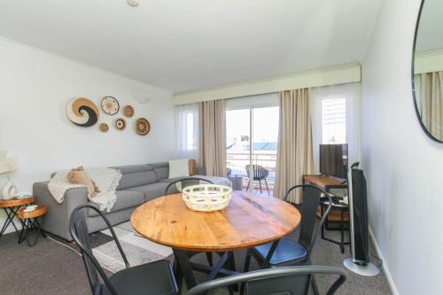 een woonkamer met een tafel en een bank bij Inner City One Bedroom Apartment with Pool View 22 in Cairns