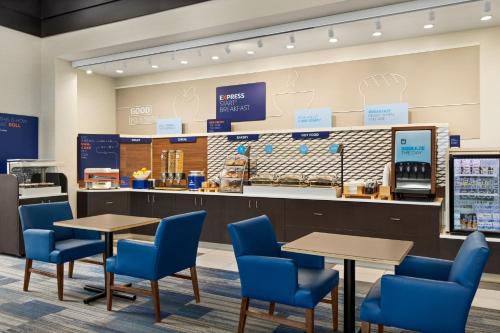 una cafetería con sillas y mesas azules y una barra en Holiday Inn Express Hotel and Suites Akron South-Airport Area, an IHG Hotel, en Akron