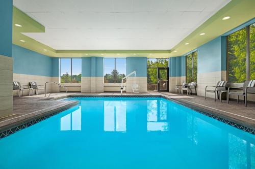 Holiday Inn Express Hotel and Suites Akron South-Airport Area, an IHG Hotel في أكرون: حمام سباحة بمياه زرقاء في غرفة في الفندق
