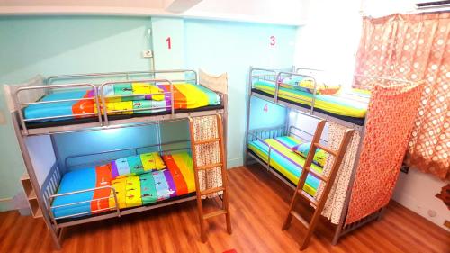two bunk beds in a room with wood floors at 站前海民宿 in Hualien City