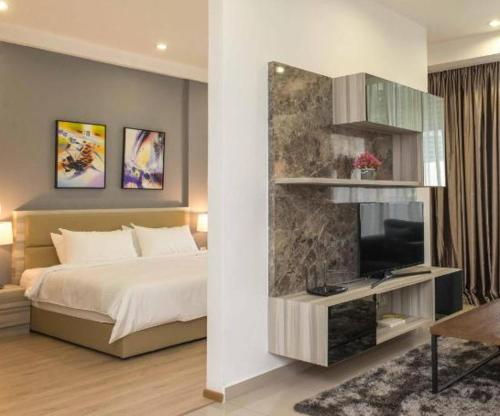 ein Schlafzimmer mit einem Bett und einem TV an der Wand in der Unterkunft Encorp Marina Suites near Legoland in Nusajaya
