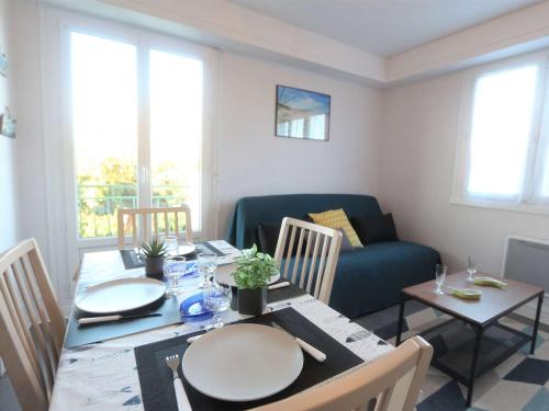 un salon avec une table et un canapé bleu dans l'établissement Appartement 3 étoiles à 150m de la plage du Letty, rénové, parking inclus - FR-1-481-97, à Bénodet