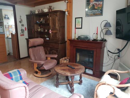 - un salon avec une chaise et une cheminée dans l'établissement Appartement Duplex pour 6 Pers, Proche Centre, Parking, Balcon Sud - FR-1-234-295, à Cauterets
