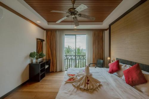 a bedroom with a large bed with a ceiling fan at Borneo Beach Villas in Kota Kinabalu