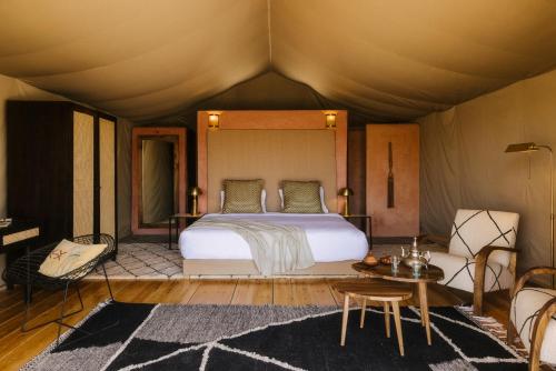 ein Schlafzimmer mit einem Bett in einem Zelt in der Unterkunft Caravan by Habitas Agafay in Marrakesch