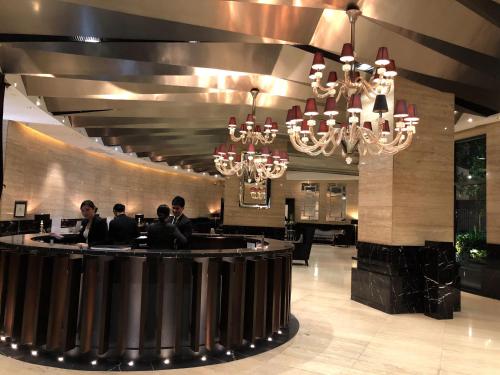 a group of people sitting at a bar in a restaurant at The Gramercy Residences in Manila