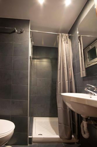 a bathroom with a sink and a shower and a toilet at Galaxy Hotel in Athens