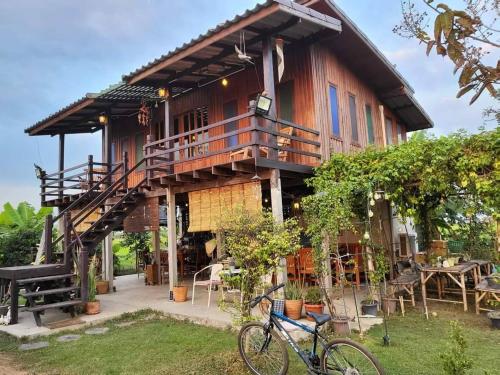 a house with a bike parked in front of it at Ban Suan Khun Yai in Phra Nakhon Si Ayutthaya
