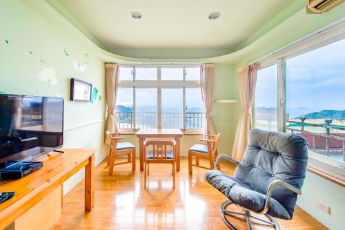 a living room with a table and chairs and a large window at Jiufen Kite Museum in Jiufen