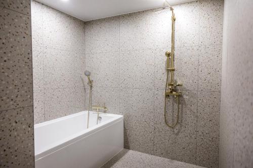 a bathroom with a white tub and a shower at Browndot Terrace Pohang Passenger Terminal in Pohang
