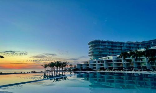 a view of a hotel and the beach at sunset at AriaOcean#410 in Nuevo Vallarta