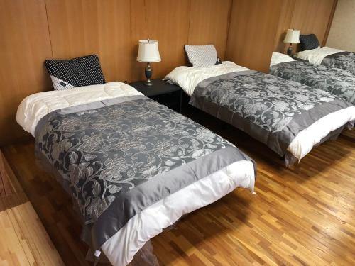 飛騨市にあるCool-Villa 飛騨リゾートのベッド3台、テーブル(ランプ付)