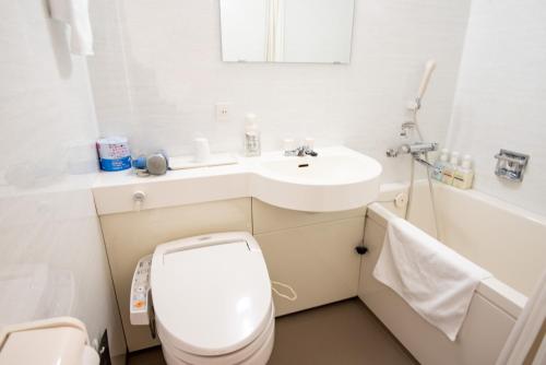 La salle de bains blanche est pourvue de toilettes et d'un lavabo. dans l'établissement le Lac HOTEL Otsu Ishiyama, à Ōtsu