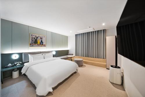 a bedroom with a large white bed in a room at Browndot Terrace Pohang Passenger Terminal in Pohang