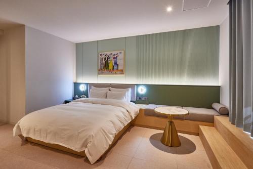 a bedroom with a large bed and a table at Browndot Terrace Pohang Passenger Terminal in Pohang