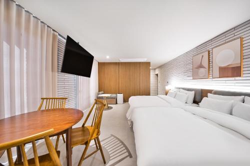 a hotel room with two beds and a table at Browndot Terrace Pohang Passenger Terminal in Pohang
