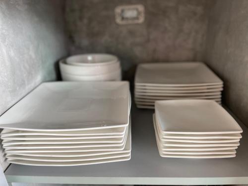 three stacks of white plates sitting on a shelf at Baan Saint-Tropez Seaview Villas Kata Beach in Kata Beach