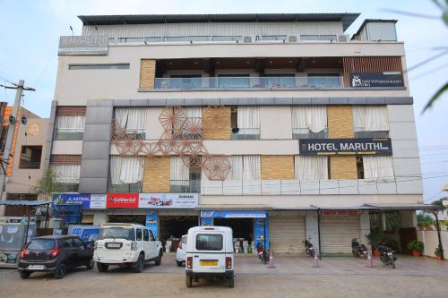 a building with cars parked in front of it at Hotel Maruthi Inn in Nirmal