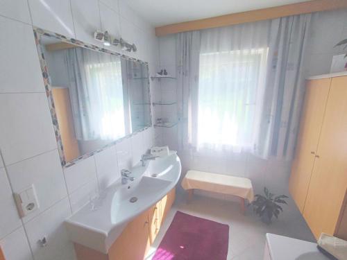 Baño blanco con lavabo y espejo en Great holiday home in Hippach with sunny terrace, en Hippach