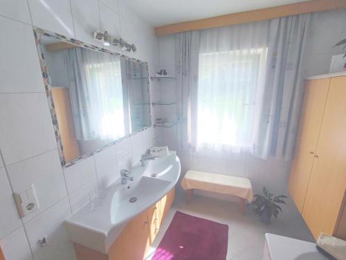 a white bathroom with a sink and a mirror at Great holiday home in Hippach with sunny terrace in Hippach
