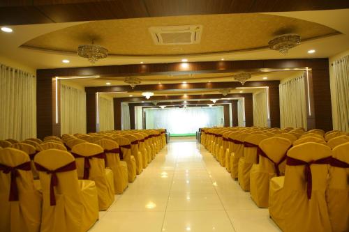 a room with rows of chairs and a screen at Hotel Maruthi Inn in Nirmal