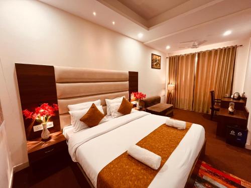 a hotel room with a large bed and a chair at Hotel Prayag INN Haridwar in Haridwār