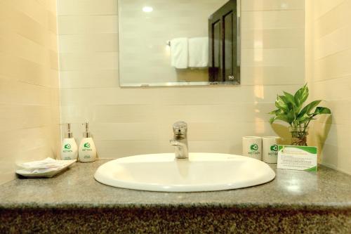 a white sink in a bathroom with a mirror at Biet Dien Hotel in Buon Ma Thuot