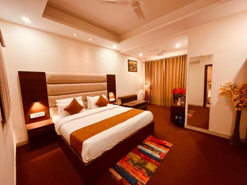a hotel room with a large bed in a room at Hotel Prayag INN Haridwar in Haridwār