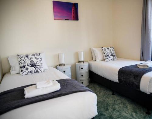 dos camas sentadas una al lado de la otra en un dormitorio en Rockpool Cottage, en Lunawanna