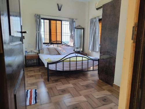 a bedroom with a bed and a wooden floor at Rajput Farm in Alibaug