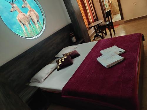 um quarto com uma cama com lençóis roxos e veados em JAIN HOTEL,Pachmarhi em Pachmarhī