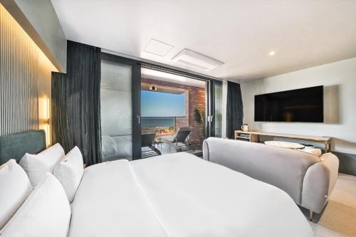 a bedroom with a white bed and a large window at Browndot Terrace Pohang Passenger Terminal in Pohang