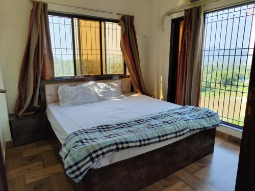 a bed in a room with windows and a bed with a bed sidx sidx sidx at Rajput Farm in Alibaug