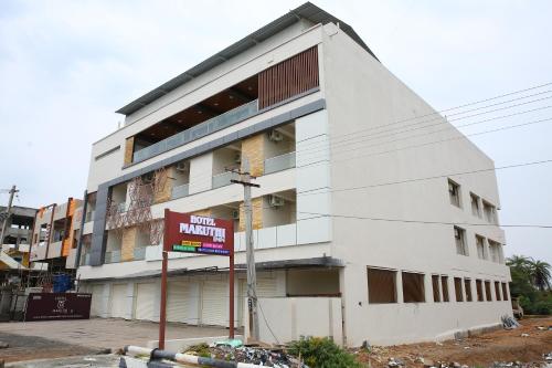 a white building with a sign in front of it at Hotel Maruthi Inn in Nirmal
