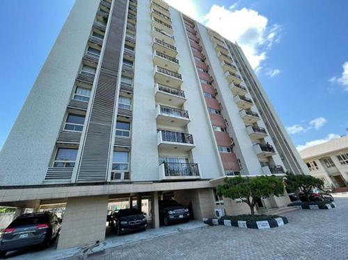 un edificio alto con coches estacionados en un estacionamiento en Elegant 3 bedrooms apartment ikoyi en Lagos