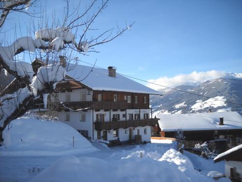 a building covered in snow with a mountain at Gästehaus Maria in Kartitsch
