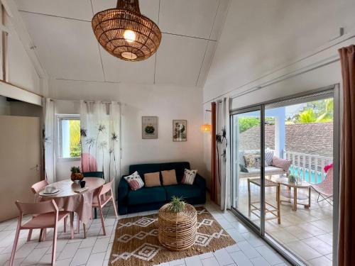 a living room with a blue couch and a table at JOLIE CREOLE- Villa sur le lagon in La Saline les Bains